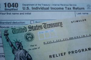 Form 1040 U.S. Individual Income tax return next to the Stimulus Check Relief program. Close up view. 