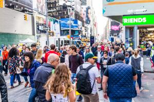 Manhattan NYC buildings of midtown Times Square, Broadway avenue road, signs ads, aerial view of many large huge crowd of people crowded walking on street crossing crosswalk outside