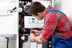 Technician servicing heating boiler