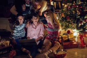 group of friends watching movie on laptop on Christmas eve