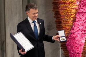 Nobel Peace Prize laureate Colombian President Juan Manuel Santos poses with the medal and diploma during the Peace Prize awarding ceremony at the City Hall in Oslo