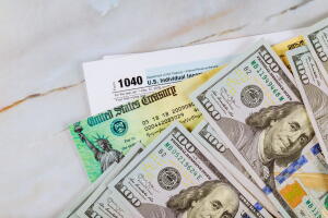 Stimulus economic tax return check and US 100 dollar bills currency
