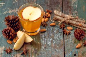 Hot drink of apple tea with cinnamon stick. Hot drink with apples for autumn or winter.