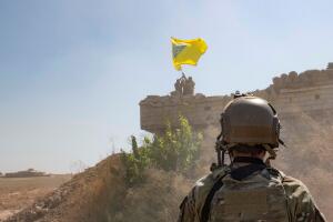 A U.S. soldier oversees members of the Syrian Democratic Forces as they demolish a YPG fortification Syria