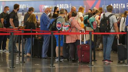 Travelers wait to check in at the delta ticket counter at Salt Lake City International Airport Tuesday, Aug. 17, 2021, in Salt Lake City. (AP Photo/Rick Bowmer)