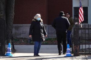 Residentes abandonan un centro de votación en la Escuela Primaria Columbus luego de votar en las elecciones primarias que se desarrollan en medio de la crisis de coronavirus.  A las 5 p.m, del martes, se habían confirmado 106 casos de coronavirus en el Illinois.