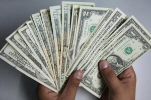 An Indian money changer poses as he coun