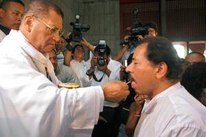 Cardinal Miguel Obando (L) gives the hos