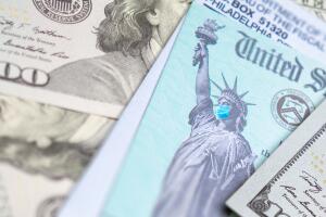 United States IRS Stimulus Check with Statue of Liberty Wearing Medical Face Mask Resting on Money