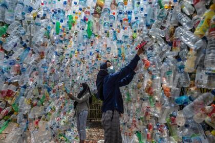 Indonesian activists from ECOTON (ecological observation and wetland conservation) prepare an installation made with used plastic, including 4,444 bottles, collected from the river in Gresik on September 17, 2021, to raise public awareness of plastic waste in rivers and oceans. (Photo by JUNI KRISWANTO / AFP) (Photo by JUNI KRISWANTO/AFP via Getty Images)