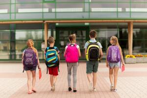 group of happy elementary school students walking