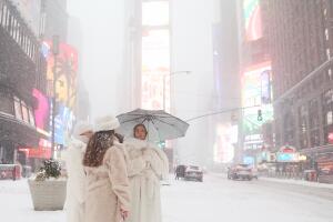 Personas caminan por las calles nevadas de Times Square durante una tormenta invernal.