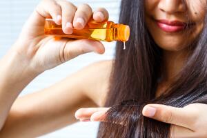 mujer poniendo aceite en su cabello