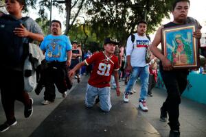 A man walks on his knees towards the Basilica of Guadalupe during the annual pilgrimage in honor of the Virgin of Guadalupe, patron saint of Mexican Catholics, in Mexico City