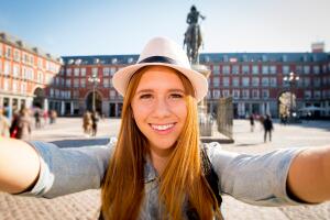 young tourist woman visiting Europe in holidays taking selfie picture