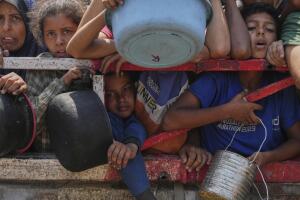 Palestinos luchan por conseguir alimentos donados en un comedor comunitario en la ciudad de Gaza, al norte de la Franja de Gaza, el sábado 26 de julio de 2025. 