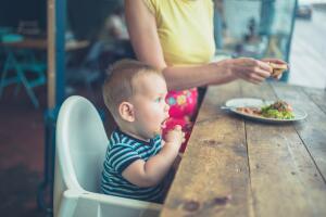Mother and baby eating in a cafe by window