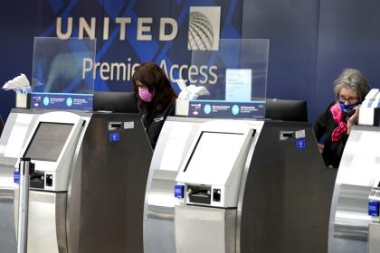 FILE -In this Oct. 14, 2020 file photo, United Airlines employees work at ticket counters in Terminal 1 at O'Hare International Airport in Chicago. United Airlines says, Thursday, Sept. 30, 2021, only about 300 employees face dismissal for refusing to get vaccinated against COVID-19, about half the number that the airline reported earlier this week. (AP Photo/Nam Y. Huh, File)