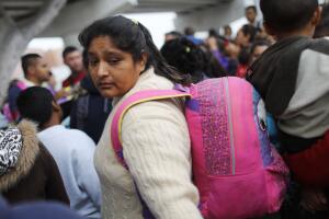 Una madre migrante entra al puerto de entrada de San Ysidro para pedir asilo.