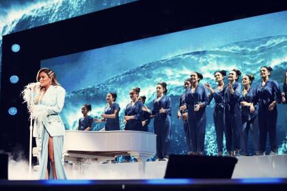 Una vez en el escenario, la intérprete usó este conjunto color aqua que diseñó ella misma, incluía detalles de plumas en las mangas.