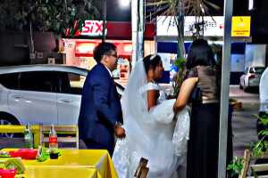 Novios acuden a un puesto callejero de tacos en plena boda