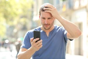 Hombre confundido al ver su celular Grosby.jpg