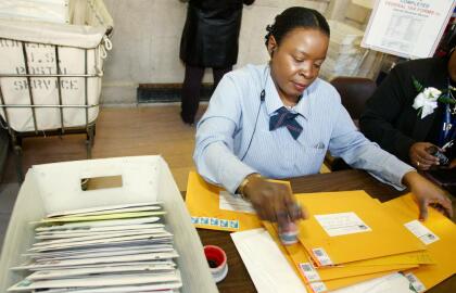 NEW YORK - APRIL 15: Joann McNeill, a postal worker at the James A. Farley post office, places cancellation stamps on envelopes bound for the IRS as last-minute tax filers get their returns in the mail just in time as the midnight deadline for filing taxes nears April 15, 2005 in New York City. The Interal Revenue Service is predicting that almost a half a million people will request extensions to filing their taxes. (Photo by Monika Graff/Getty Images)