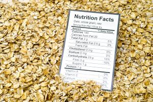 Nutrition facts of whole grain raw oats with oats background.