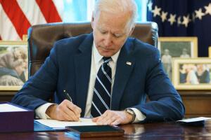 El presidente Joe Biden firma el paquete de estímulo económico el 11 de marzo del 2021 en la Oficina Oval de la Casa Blanca.
