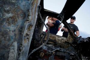 Relatives of slain members of Mexican-American families belonging to Mormon communities react next to the burnt wreckage of a vehicle where some of their relatives died, in Bavispe