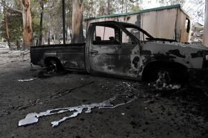 A burnt out vehicle is seen at a destroyed property in Sarsfield in East Gippsland