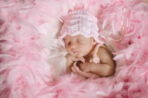 bebé dormida sobre plumas rosas