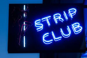 Girls strip club blue neon sign and woman silhouette