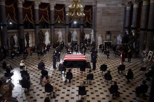 Miembros del Congreso sentados ante el féretro de Ruth Bader Ginsburg en el Salón de las Estatuas del Capitolio.