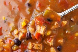 Top view of chicken tortilla soup with a spoon in the food.