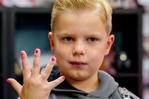 Niño presume sus uñas pintadas