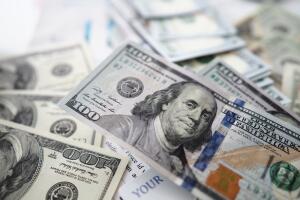 Rich amount of US paper hundred dollars lying on table