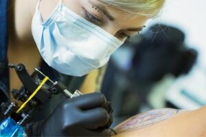 mujer tatuadora usando una maquina