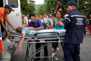 Paramedics help a relative of inmates held at the General Command of the Carabobo Police in Valencia