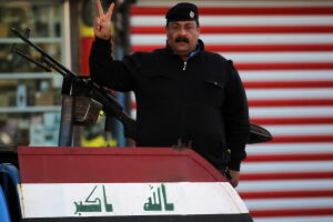 Un policía iraquí hace la señal de la victoria durante el desfile de celebración de triunfo sobre ISIS en Bagdad el 10 de dociembre de 2017.