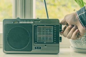 hand adjusting the settings of vintage old radio, search for radio station wave f