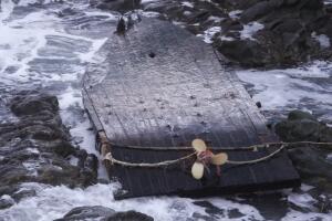 Washed up and flipped over wooden ghost ship with propeller facing up