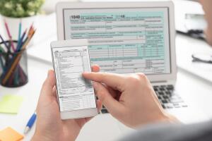 Man filling tax information using mobile devices