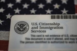 Back side of employment authorization card by US Citizenship and Immigration Services (USCIS) on American flag background.