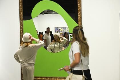 Attendees admire art at the VIP preview day for Art Basel on Wednesday, Dec. 4, 2024, at Miami Beach Convention Center in Miami Beach. (Photo by Scott Roth/Invision/AP)