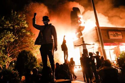 Fotografías ganadoras del World Press Photo 2021 | Al Dia Media Protesters raise their fists in defiance outside a burning fast food restaurant near the Minneapolis Police Department 3rd Precinct, Friday, May 29, 2020, in Minneapolis. (AP Photo/John Minchillo)