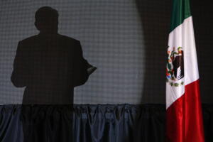 La sombra de López Obrador se proyecta sobre el escenario donde da su discurso del triunfo.
