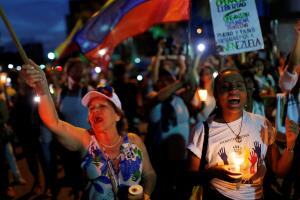 People attend a candlelight vigil held for victims of recent violence in Caracas