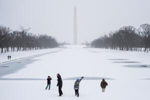 La gente camina por el National Mall mientras cae nieve.