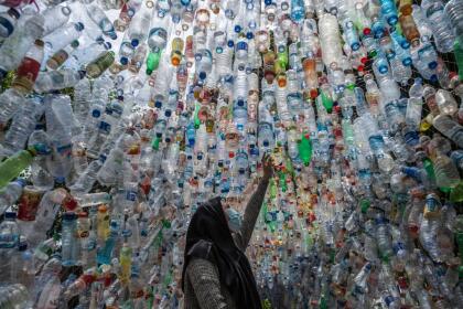An Indonesian activist from ECOTON (ecological observation and wetland conservation) prepares an installation made with used plastic, including 4,444 bottles, collected from the river in Gresik on September 17, 2021, to raise public awareness of plastic waste in rivers and oceans. (Photo by JUNI KRISWANTO / AFP) (Photo by JUNI KRISWANTO/AFP via Getty Images)